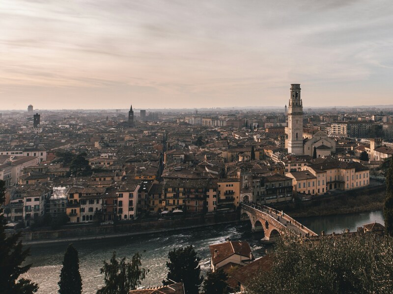 ista panoramica di Verona dall’alto, con il fiume Adige, Ponte Pietra e il centro storico dominato dalla Torre dei Lamberti.
