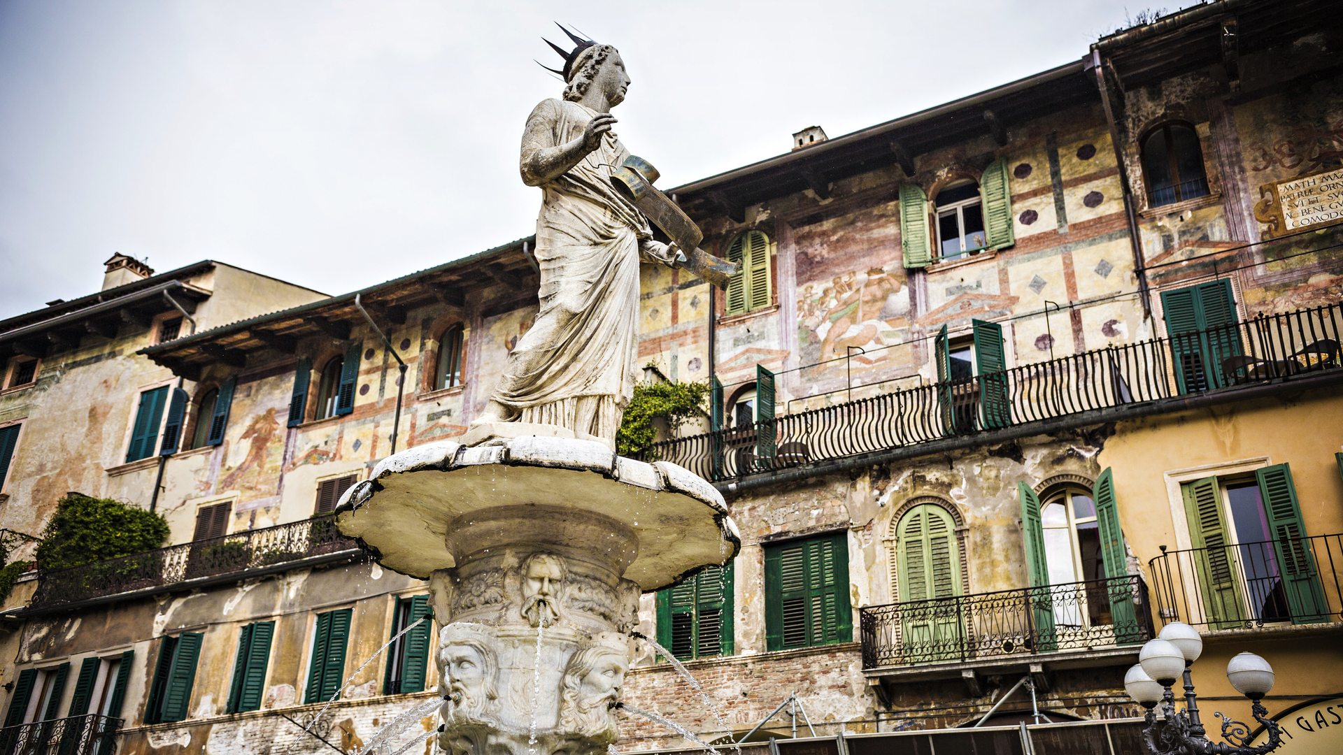 ontana di Madonna Verona in Piazza delle Erbe, con la statua al centro e gli edifici storici affrescati sullo sfondo.